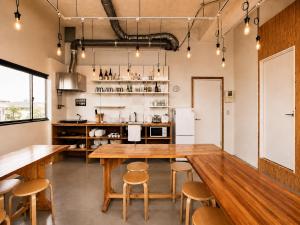 a kitchen with a large wooden table and chairs at Ishigaki Guesthouse HIVE in Ishigaki Island