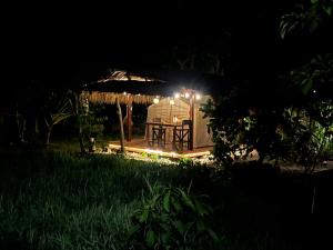 a lit up gazebo in a field at night at Soffta Surf Ranch in General Luna