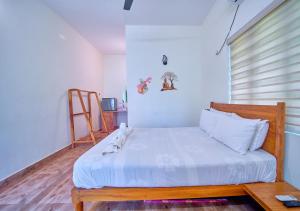 a small bedroom with a bed with white sheets at Ocean View Beach Villa Varkala by VOYE HOMES in Varkala