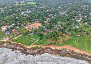an aerial view of a house on a island next to the ocean at Ocean View Beach Villa Varkala by VOYE HOMES in Varkala