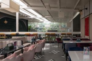 a dining room with tables and chairs andwindows at Ello Hotels in Bangalore