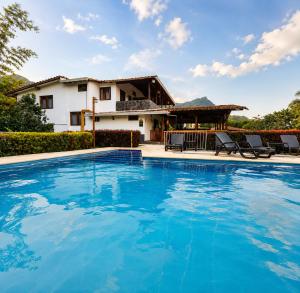 a villa with a swimming pool and a house at Hotel Campestre Alameda in Támesis