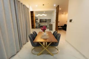 a dining room table with chairs and a vase of flowers on it at Rivera Residency , Kazhakuttom in Murukkumpuzha