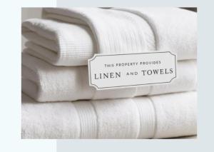 a pile of towels with a sign that reads this property provides linen and towels at In Da Block - Beachy Haven in Inverloch