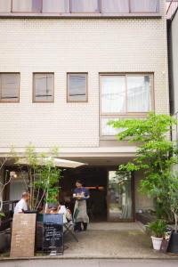 a woman standing in front of a building at Hostel Niniroom in Kyoto
