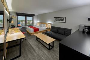 a hotel room with a bed and a couch at City Express by Marriott Monterrey Aeropuerto in Monterrey +46 photos