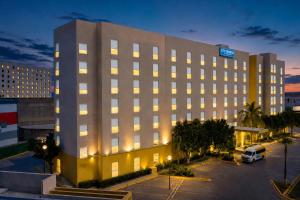 a large building with lights on in a parking lot at City Express by Marriott Monterrey Aeropuerto in Monterrey