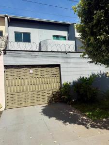 a building with a garage door and a house at Sobrado Flamboyant in Goiânia