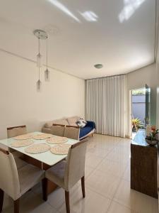 a dining room and living room with a table and chairs at Sobrado Flamboyant in Goiânia