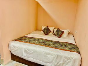 a small bed in a corner of a room at Avigat Kabir hotel sanwer in Sānwer +4 photos