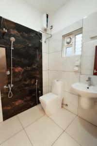 a white bathroom with a toilet and a sink at Rivera Residency , Kazhakuttom in Murukkumpuzha