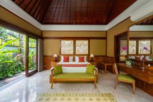 a bedroom with a bed and a desk at Arkamara Dijiwa Ubud in Ubud