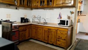 a kitchen with wooden cabinets and a microwave on a counter at "Alojamiento en Uspallata" para hasta 6 personas in Uspallata