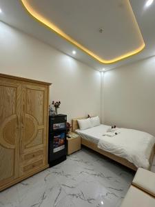 a bedroom with a bed and a wooden cabinet at Tân Hiệp 2 Hotel in Bùi Tiếng +36 photos