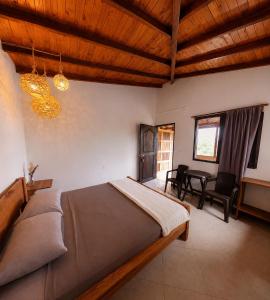 a bedroom with a bed and a table and chairs at Hotel Campestre Alameda in Támesis +4 photos