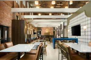 a dining room with tables and chairs and a tv at SpringHill Suites by Marriott High Point Downtown in High Point