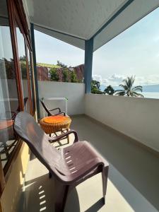 a balcony with a chair and a table at Maruba inn in Tuktuk Siadong