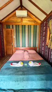 a bed in a room with two towels on it at Beach Camp Lombok in Sekotong