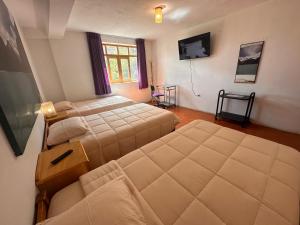 a bedroom with two beds and a couch in it at Amelita Hotel Boutique in Huaraz
