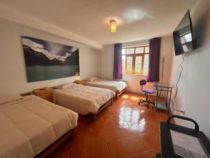 a hotel room with two beds and a flat screen tv at Amelita Hotel Boutique in Huaraz