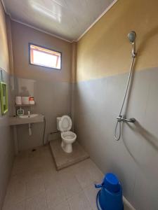 a small bathroom with a toilet and a shower at Maruba inn in Tuktuk Siadong