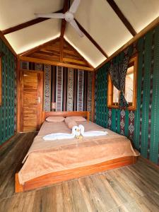 a large bed in a room with green walls at Beach Camp Lombok in Sekotong