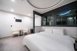 a bedroom with a large white bed and a table at W Hotel in Yangsan