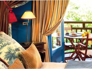a room with a couch and a table on a balcony at Villa MARSAN - Maison Hervé-Martin GARRAPIT in Villeneuve-de-Marsan