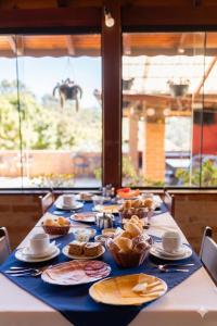 a long table with food and a horse in the background at Pousada Palma Chalés in Monte Verde