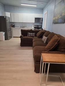 a living room with a brown couch and a kitchen at River Run Bo's Place in Kerrville