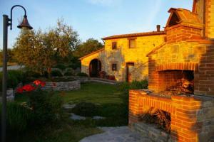 a brick house with a fireplace in a yard at Agriturismo Valiana in Montegabbione