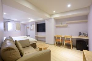a room with a couch and a bed and a table at Members Hotel at Taipei 101 in Taipei