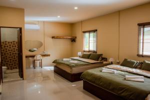 a bedroom with two beds and a bathroom at Koh Tao Stay in Ko Tao