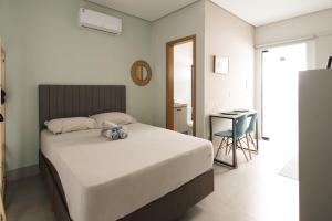 a bedroom with a bed with a stuffed animal on it at 4-Studio Completo com Ar-Condicionado, TV e Lavanderia in Londrina