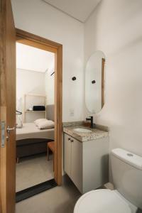 a bathroom with a toilet and a sink and a bed at 4-Studio Completo com Ar-Condicionado, TV e Lavanderia in Londrina +69 photos