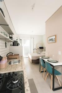 a kitchen and living room with a bed in the background at 4-Studio Completo com Ar-Condicionado, TV e Lavanderia in Londrina