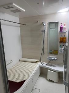 a small bathroom with a shower and a sink at Tokyo Shinichi House A in Tokyo +7 photos