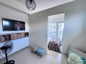 a living room with a fan a table and a window at Condo Unit at Cool Suites SMDC Wind Tagaytay in Tagaytay