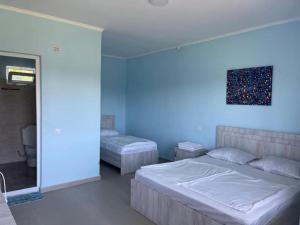 a bedroom with two beds and a painting on the wall at jibo in Grigoleti