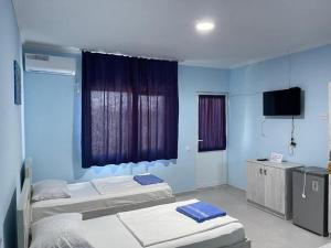 a hospital room with two beds and a television at jibo in Grigoleti
