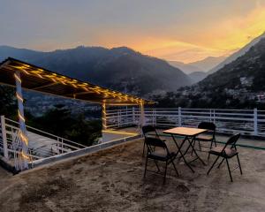 a table and chairs on a roof with a view at Cedar Crest Homestay in Kulu +13 photos