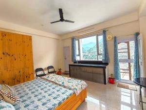 a bedroom with a bed and a large window at Cedar Crest Homestay in Kulu
