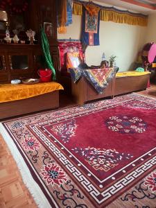 a bedroom with two beds and a red rug at Lama home in Bālāju