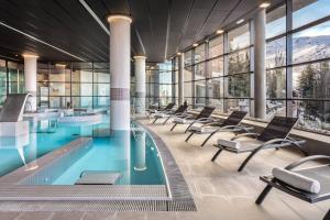a pool with chairs in a building at Meliá Sierra Nevada in Sierra Nevada