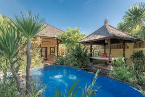 a villa with a swimming pool and a gazebo at Villa KaRo Pemuteran in Pemuteran