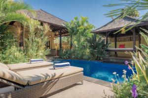 a backyard with a swimming pool and a house at Villa KaRo Pemuteran in Pemuteran