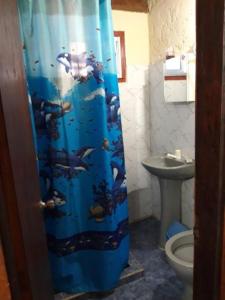 a bathroom with a blue shower curtain with fish on it at Los Rochas, Barra de Chuy in Barra del Chuy +35 photos