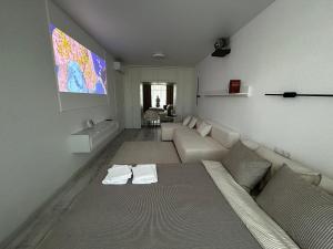 a living room with a couch and a flat screen tv at Bila Perlyna - Люкс, пляж, паркінг, укриття in Odesa