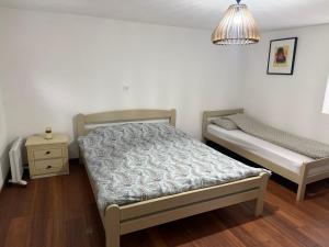 a bedroom with two beds and a night stand at Casa Illyria in Gusinje