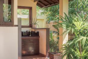 a kitchen with a dresser in a room with plants at Villa KaRo Pemuteran in Pemuteran